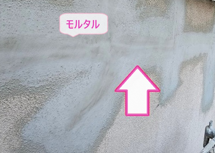 モルタル壁の部分修理工事の仕上げに新しくモルタルを塗っている様子