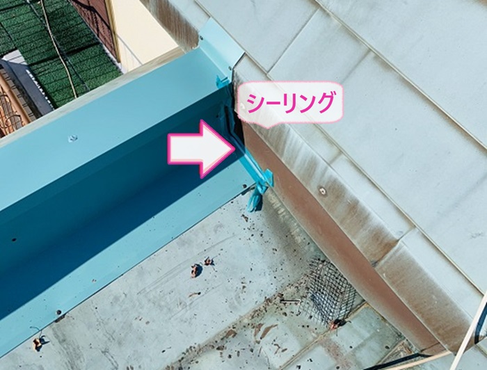 神戸市中央区の屋根板金工事で交換した笠木の端部にシーリングを打設している様子