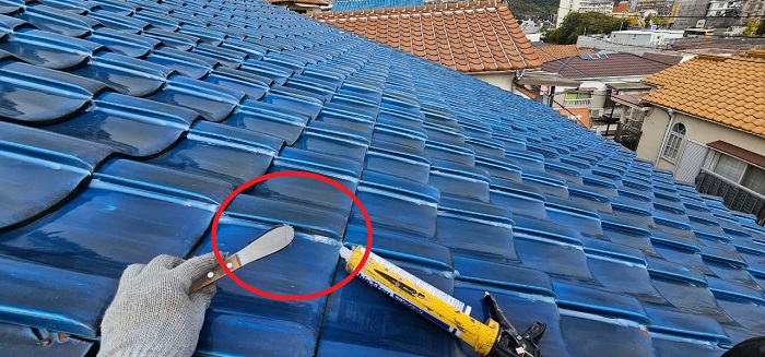 ラバーロック工法で瓦屋根の縦目地にシーリングを塗っている様子