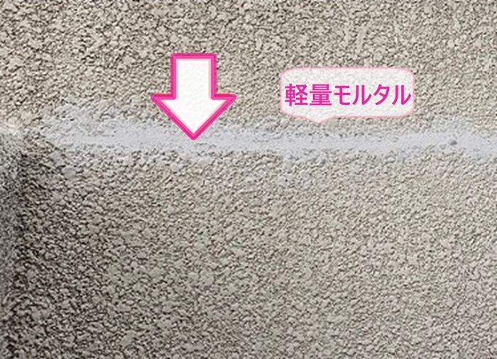 住宅外装メンテナンスで壁面のひび割れを軽量モルタルで補修している様子