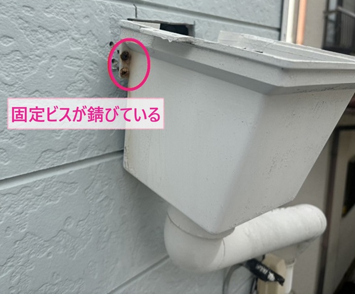 集合住宅で雨樋の固定ビスが錆びて集水桝が外れている様子