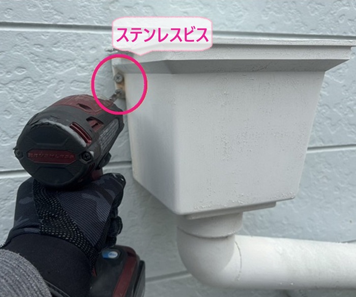 集合住宅の雨樋の安全対策でステンレスビスで雨樋を固定している様子