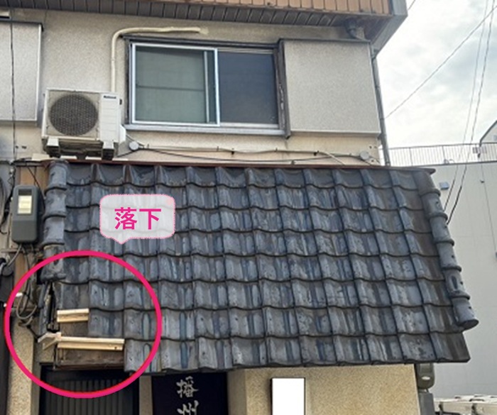 店舗瓦屋根の葺き替え工事で既存の瓦屋根が落下している様子