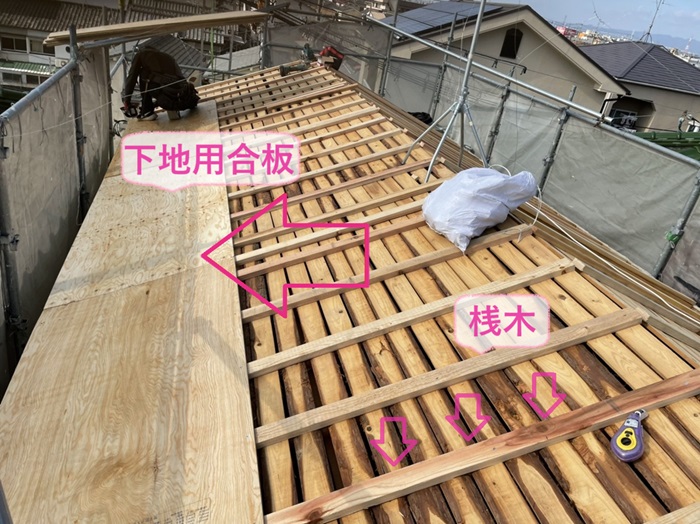 神戸市長田区の屋根改修工事で小幅板の上に桟木を取り付けて、その上に下地用合板を取り付けている様子