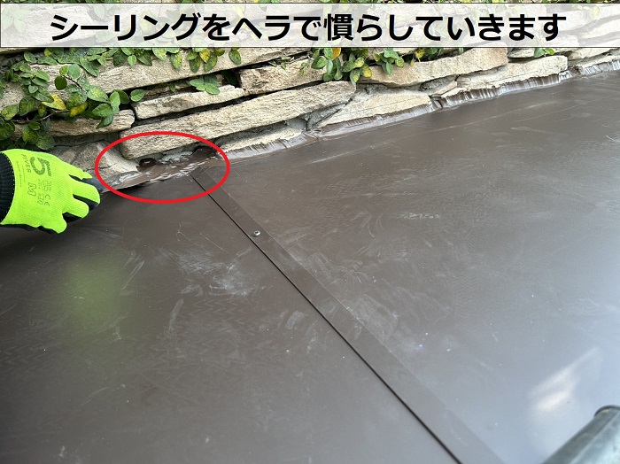 屋根勾配を変える庇屋根の水漏れ修理でシーリングをヘラで慣らしている様子