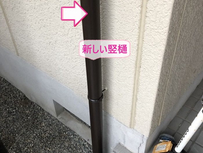 芦屋市の雨樋交換で新しい竪樋を取り付けている様子