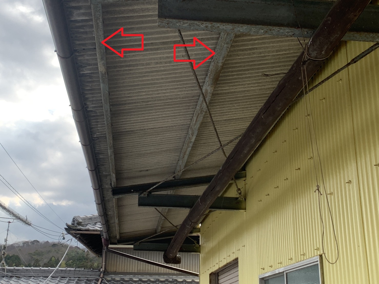 倉庫のスレート屋根波板の鉄骨下地が錆び付いている様子