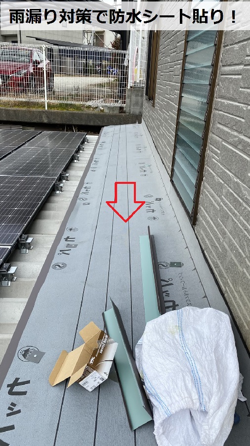 緩傾斜なスレート屋根の上に防水シートを貼っている様子