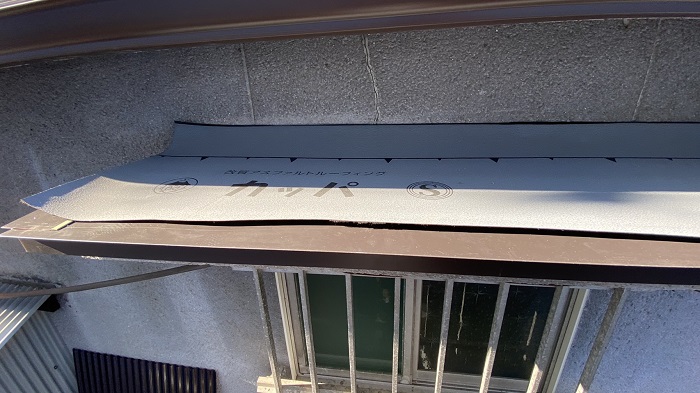 庇屋根の板金修理工事で防水シートを貼った様子