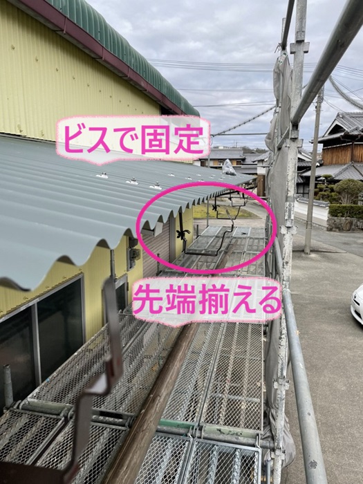 神戸市西区の農業倉庫でガルバリウム鋼板屋根の先端をそろえてからビスで固定している様子