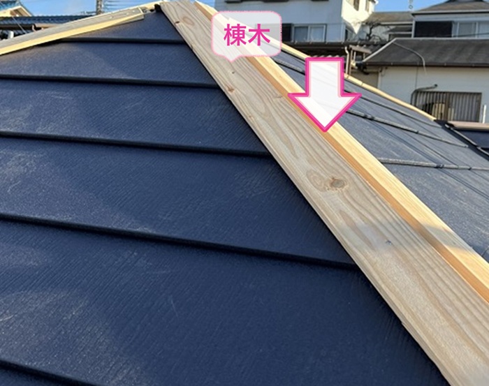 ３階建て住宅の屋根重ね葺き工事で棟木を取り付けている様子