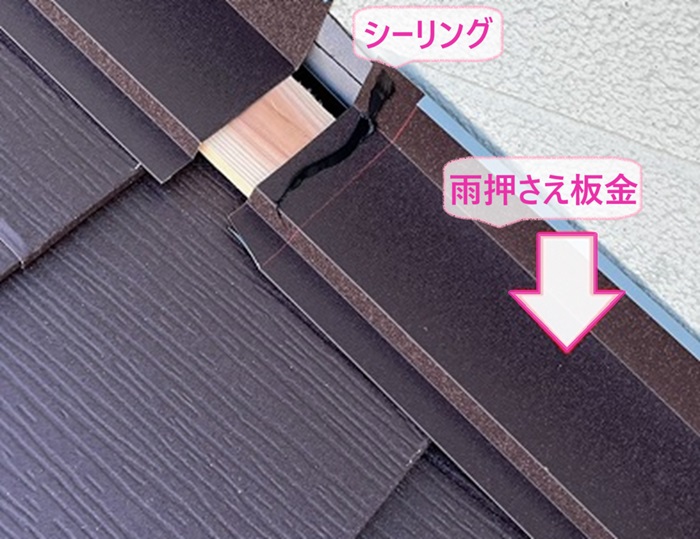 軽量瓦の葺き替え工事で壁際に雨押さえ板金を取り付けている様子