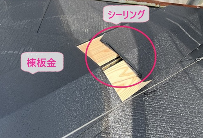 緩傾斜な屋根の重ね葺き工事で棟板金を取り付けている様子