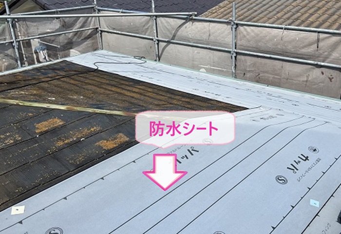 緩傾斜な屋根の重ね葺き工事で防水シートを貼っている様子