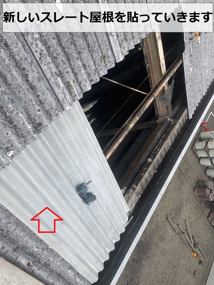 工場の屋根修理で新しいスレート屋根を貼っている様子