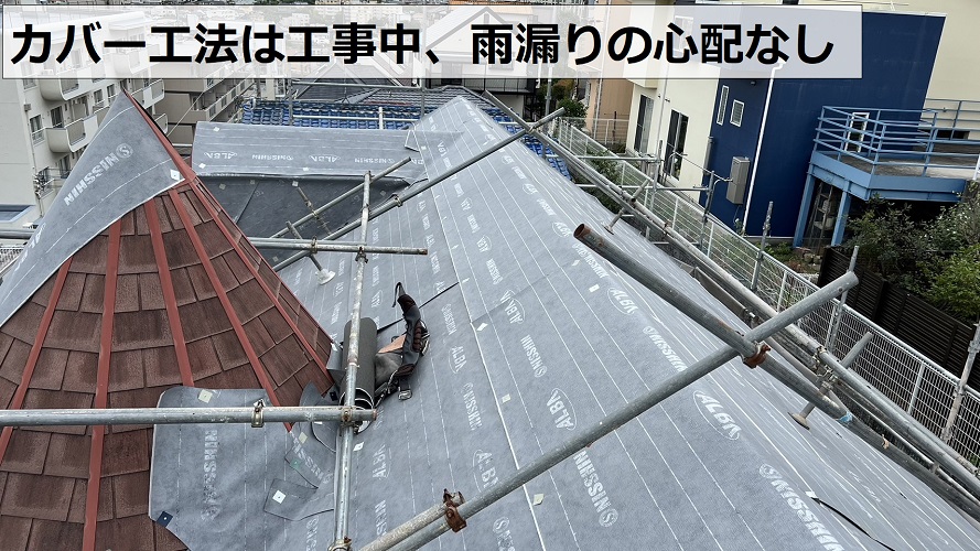 スレート屋根の上から防水シートを貼っている様子