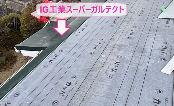 瓦屋根と複合したカラーベスト屋根へ断熱屋根材のIG工業スーパーガルテクトを葺いている様子