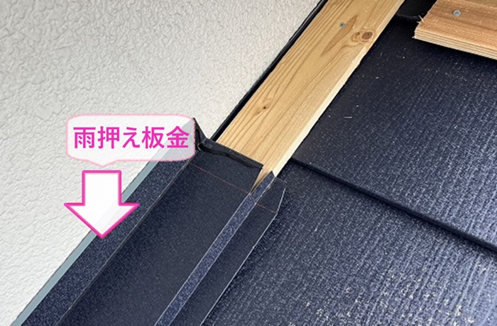 塗装済みカラーベストのカバー工事で壁際に雨押さえ板金を取り付けている様子