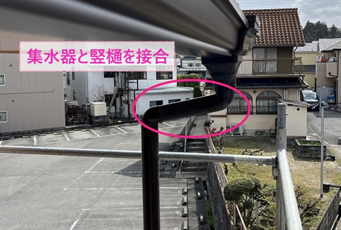 集合住宅の２階軒樋交換で集水器と竪樋を接合している様子