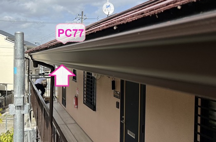 集合住宅の２階軒樋交換で新しい雨樋のPC77を取り付けている様子