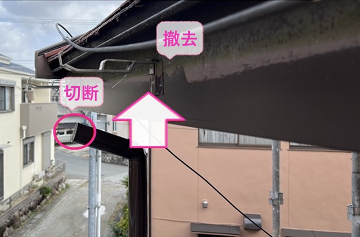 集合住宅の２階軒樋交換で既存の軒樋を竪樋から切断して撤去している様子