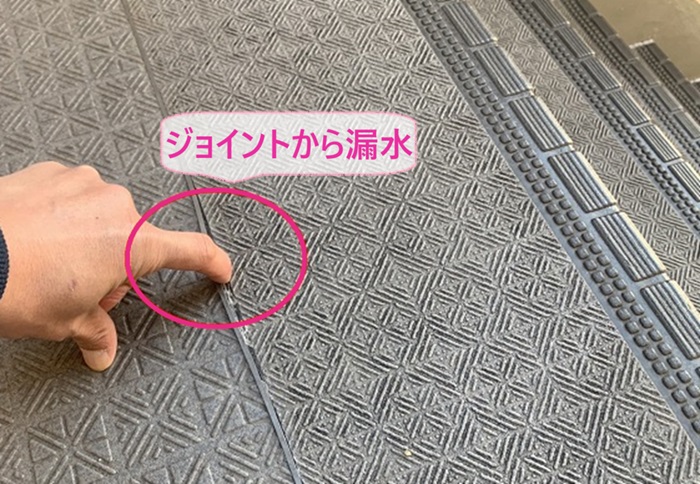 補修する3階建てマンションの既存の階段のジョイントが漏水している様子