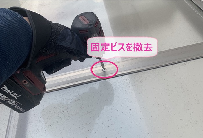 エアコン室外機の取り付けでガレージ屋根の固定ビスを撤去している様子
