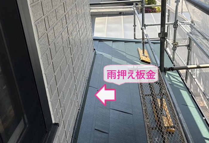 屋根カバー工法の最後に壁際に雨押さえ板金を設置している様子