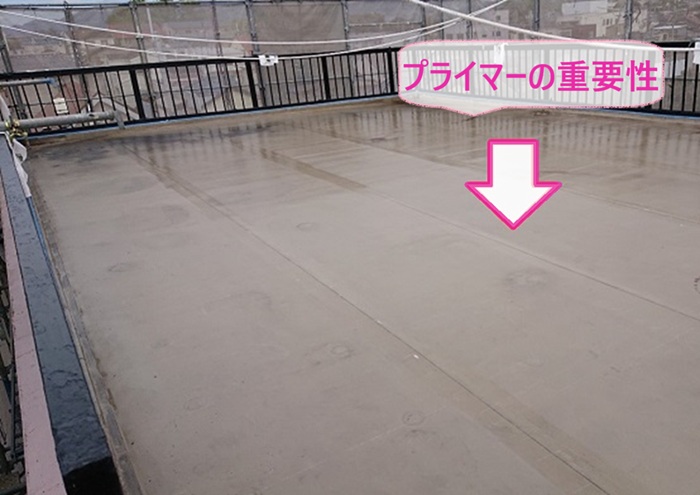 ビル屋上の防水改修でプライマーを塗る重要性を説明している様子