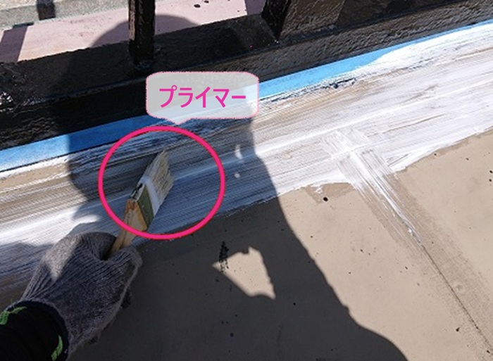 ビル屋上の防水改修でプライマーを塗っている様子