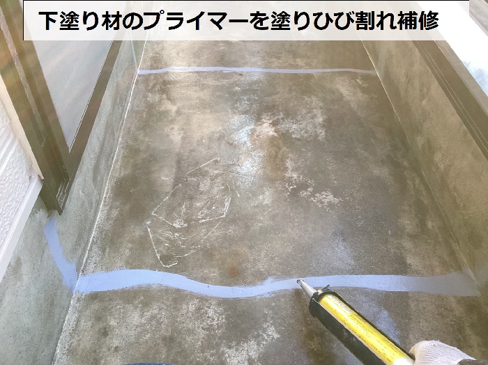 尼崎市でのベランダ防水工事で下塗り材を塗りひび割れ補修している様子