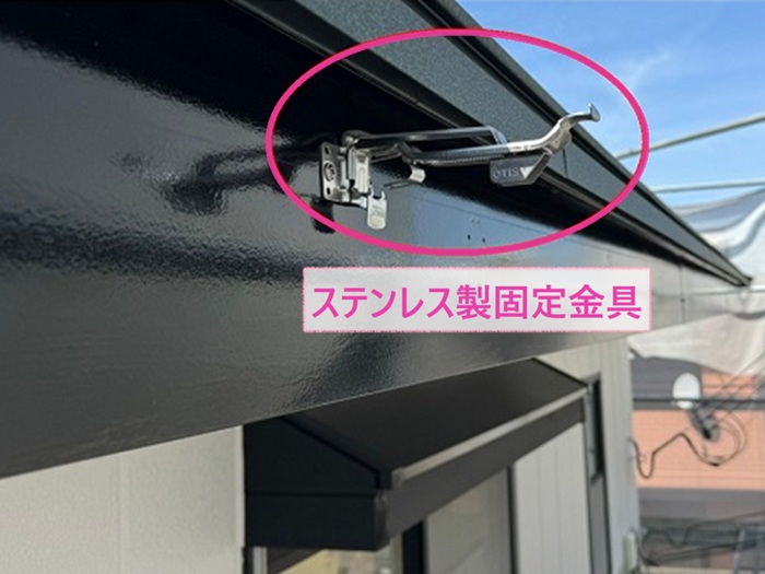 雨水排水設備の交換でステンレス製の固定金具を取り付けている様子