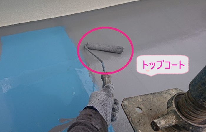 ベランダ床へのウレタン防水密着工法でトップコートを塗っている様子