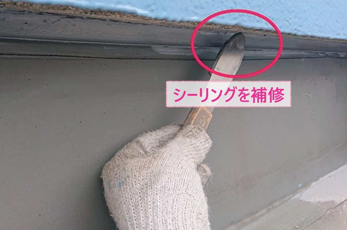 陸屋根シート防水の改修工事でひび割れたシーリング材を補修している様子