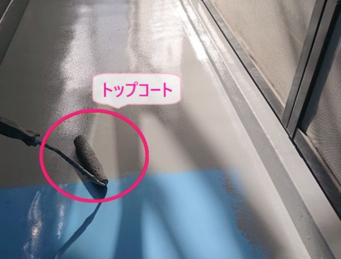 集合住宅のバルコニー防水工事でトップコートを塗っている様子