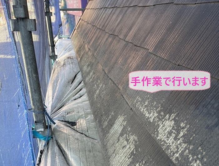 スレート庇の塗り替え工事で高圧洗浄の代わりに手作業でケレンしている様子
