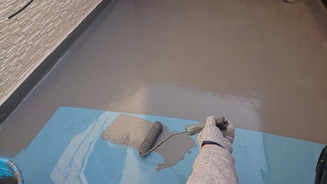 加古郡稲美町での防水工事でトップコートを塗っている様子