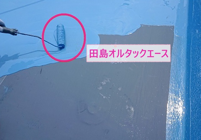 伊丹市の陸屋根防水改修工事で田島オルタックエースを塗っている様子