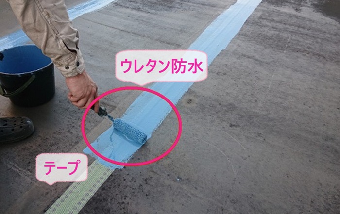 商業施設の屋上防水リフォームでジョイントにテープを貼ってウレタン防水を塗っている様子
