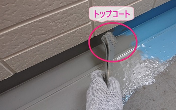 集合住宅の共用廊下のリフォームでトップコートを塗っている様子