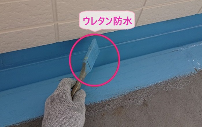 集合住宅の共用廊下のリフォームでウレタン防水を塗っている様子