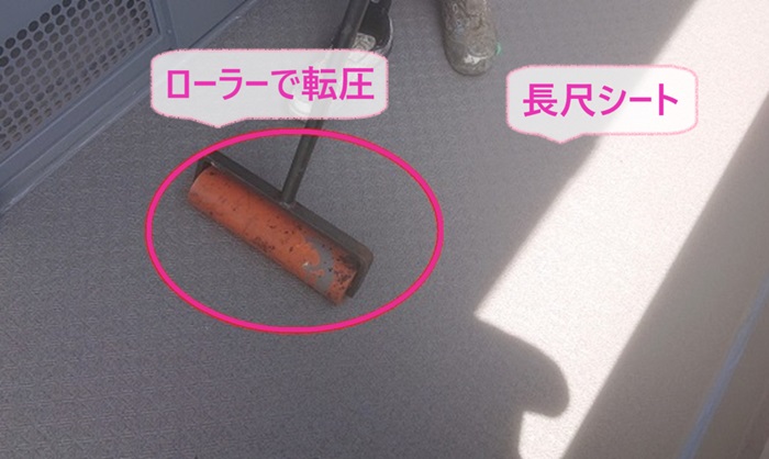 集合住宅の共用廊下のリフォームで長尺シートを貼ってローラーで転圧している様子
