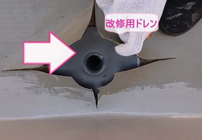 加古川市の穴の空いた塩ビシート防水の部分補修で改修用ドレンを取り付けている様子