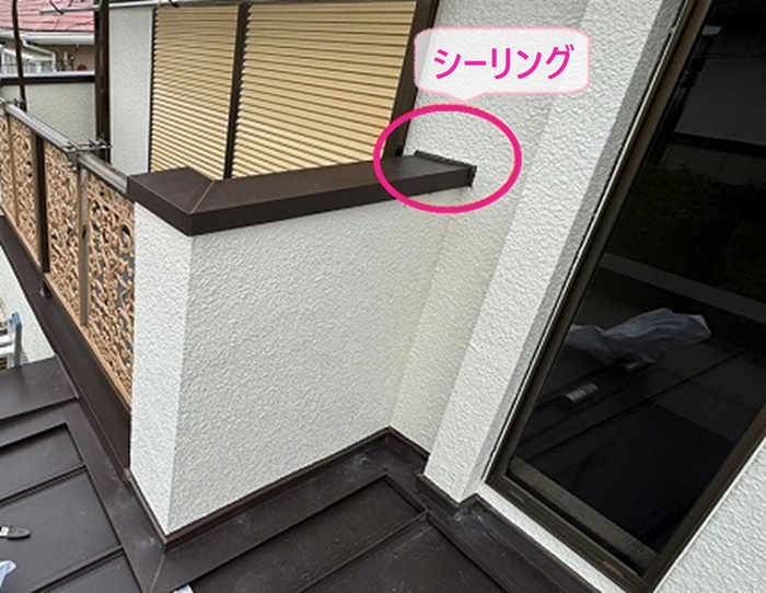 バルコニー天端の雨仕舞いで端部にシーリングを打設している様子