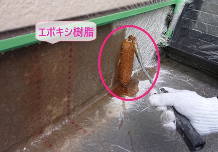 FRP防水リフォームでガラス繊維のマットにエポキシ樹脂を塗っている様子