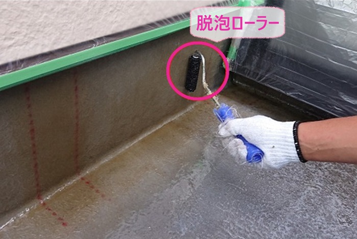 FRP防水リフォームで脱泡ローラーで脱泡作業をしている様子