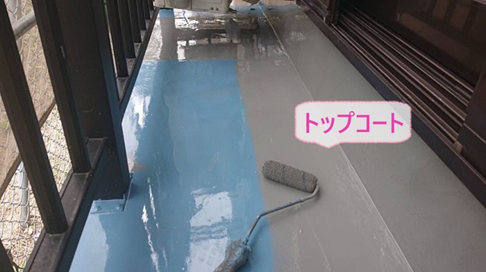 神戸市中央区の防水工事でバルコニー床にトップコートを塗っている様子