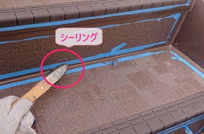 集合住宅の外階段メンテナンスでシーリングを打っている様子