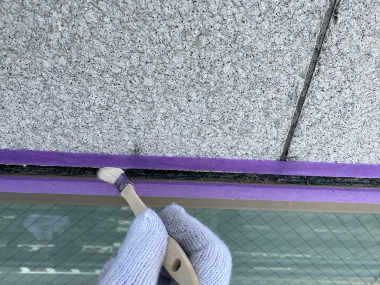 神戸市中央区でのコーキング打ち替え工事でプライマーを塗っている様子