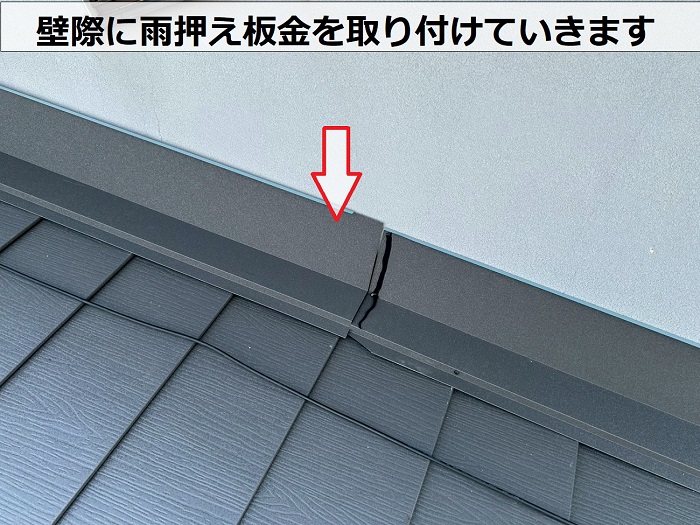 壁際に雨押え板金を取り付けている様子